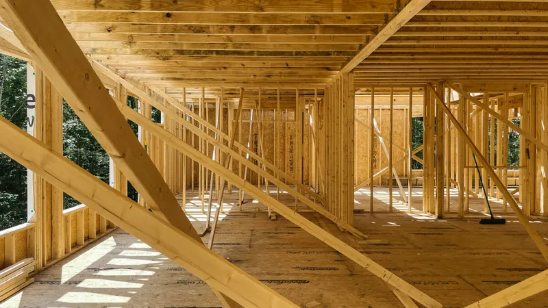 Open wood stud walls, floor joists, and temporary bracing define rooms before the interior is closed in.
